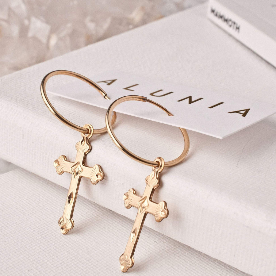 Gold cross hoop earrings for women on an alunia jewelry card